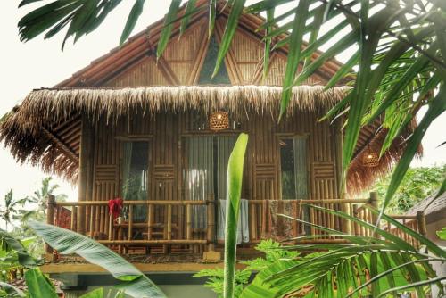 a bamboo house with a thatch roof at Pondok Salacca#bamboohouse# in Candidasa