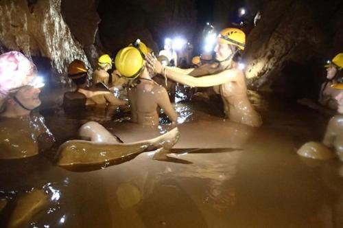 a group of people in the water in a cave at Hugo Homestay in Phong Nha