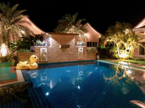 a swimming pool at night with lights on a house at Chang Noi Hua Hin Pranburi fully accessible barrierefrei resort in Ban Nong Sua