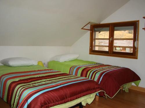 two beds in a room with a window at Les Sens Ciel in Corrençon-en-Vercors