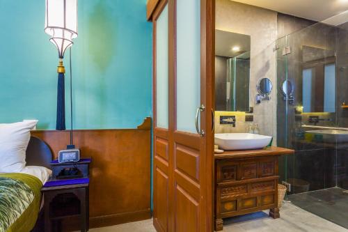 a bathroom with a sink and a glass shower at Lao Poet Hotel in Vientiane