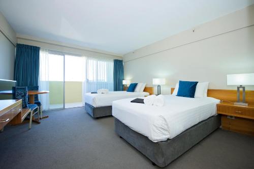 a hotel room with two beds and a television at The Lord Forrest Hotel in Bunbury
