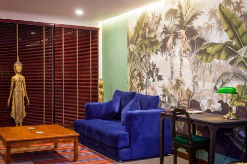 a living room with a blue couch and a table at Lao Poet Hotel in Vientiane