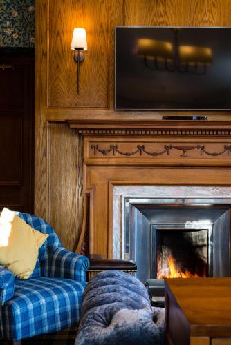 a living room with a couch and a fireplace at Murrayshall Country Estate in Perth