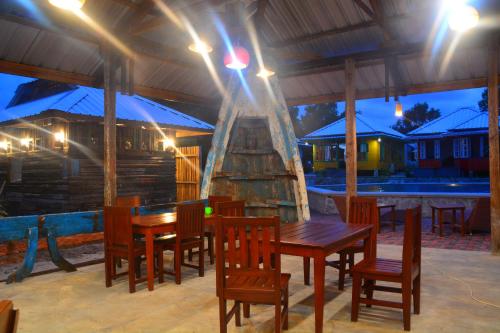 a wooden table and chairs on a patio at night at Rock and Wreck Dive Resort in Tanjungbinga