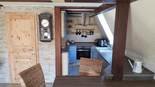 a kitchen with blue cabinets and a table and chairs at Ferienhaus am Lübbesee in Milmersdorf