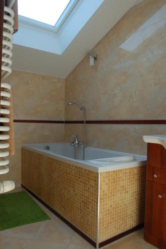 a bath tub in a bathroom with a skylight at DOM WESELNY ,, ANNA'' in Warlubie
