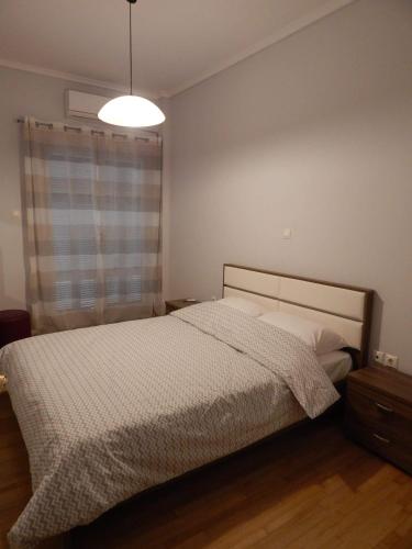 a bedroom with a bed and a lamp in it at ATHENS RIVIERA SEA VIEW APARTMENT in Piraeus