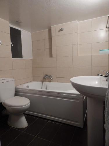 a bathroom with a tub and a toilet and a sink at ATHENS RIVIERA SEA VIEW APARTMENT in Piraeus