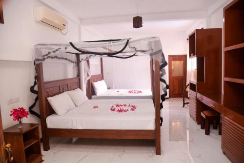 ein Schlafzimmer mit einem Himmelbett in der Unterkunft Hotel Nadee in Aluthgama