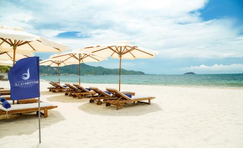 a group of chairs and umbrellas on a beach at Boton Blue Hotel & Spa in Nha Trang