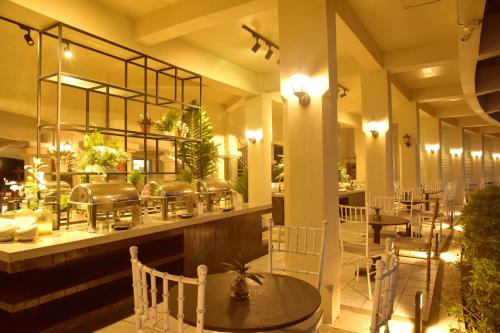 a restaurant with tables and chairs in a room at Forest Crest Nature Hotel and Resort Powered by ASTON in Nasugbu