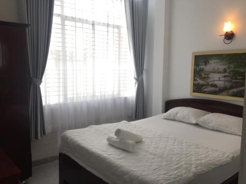 a bed with a white towel on top of it at Vy Khanh Guesthouse in Ho Chi Minh City