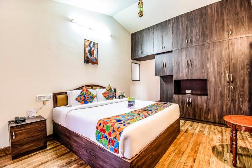 a bedroom with a bed and a wooden wall at FabEscape Saint Clouds in Ooty