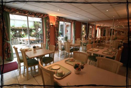 巴涅爾－德比戈爾的住宿－派克斯酒店，餐厅设有桌椅和大窗户。