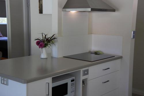 a kitchen with a counter with a sink and a microwave at Sapphire Chalets, Augusta in Augusta