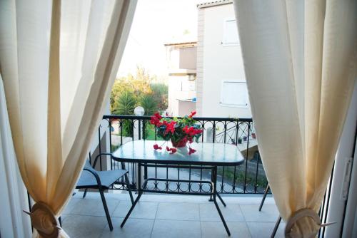 a table with a vase of flowers on a balcony at Corfu Don Camillo Apartment in (( Agía Eleoúsa ))