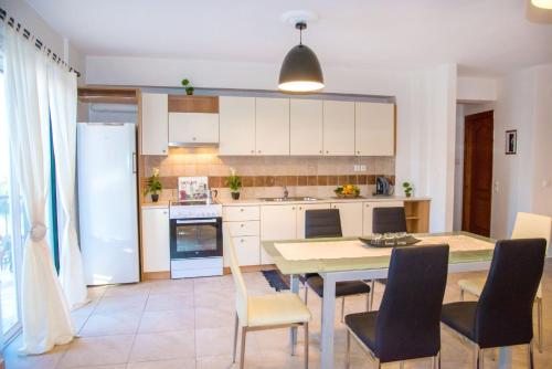 a kitchen and dining room with a table and chairs at Corfu Don Camillo Apartment in (( Agía Eleoúsa ))