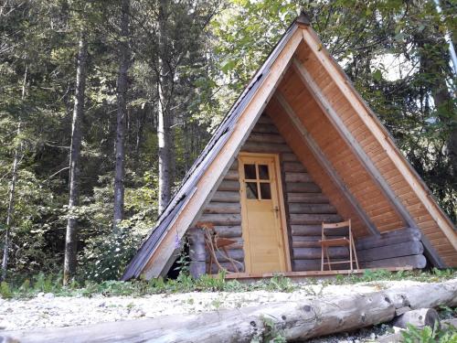 una cabaña en el bosque con una puerta amarilla en Camp ŠMICA, en Luče