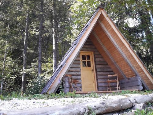 a cabin in the woods with a yellow door at Camp ŠMICA in Luče