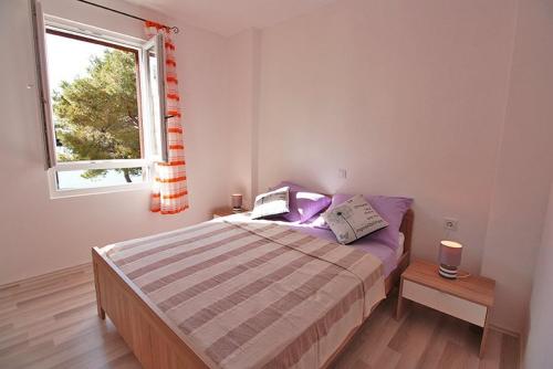 a small bedroom with a bed and a window at Apartman Petra in Fažana
