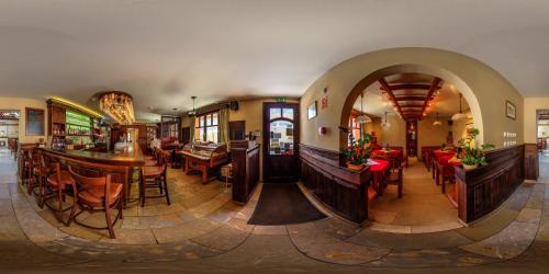 um restaurante com mesas e cadeiras e um bar em Pastorale Apartman em Zalaszentgrót
