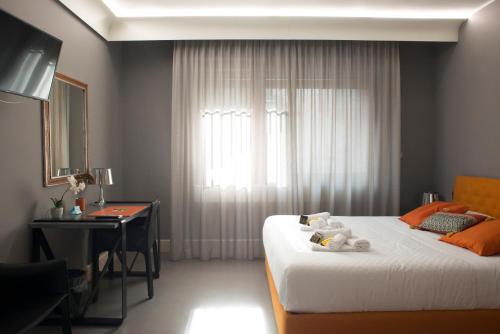 a bedroom with a bed and a desk and a window at Principessa Mafalda in Messina