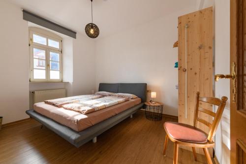 a bedroom with a bed and a chair and a window at Kabine 30 Innenstadt, EG, Wlan inkl. Haustiere willkommen in Rüdesheim am Rhein