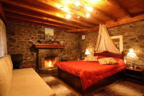 1 dormitorio con cama roja y chimenea en Elka, en Palaios Agios Athanasios