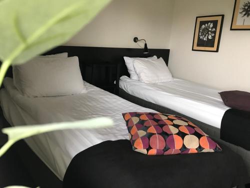 two beds in a room with a chair and a pillow at Rasta Kalmar in Kalmar