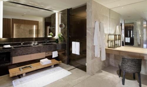 a bathroom with a sink and a mirror and a stool at Four Seasons Hotel Kyoto in Kyoto
