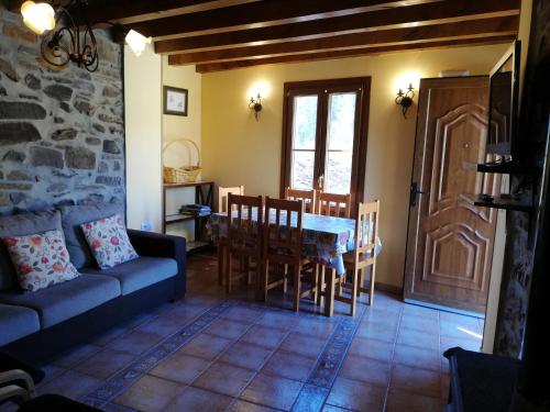 a living room with a couch and a table and chairs at Casa Rural LA HUERTA DE POTES in Cabezón de Liébana