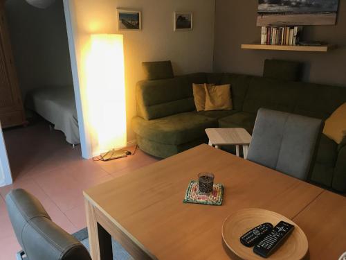 uma sala de estar com uma mesa e um sofá em Ferienwohnung-Strandspaziergang, kleine Wohnung em Börgerende-Rethwisch