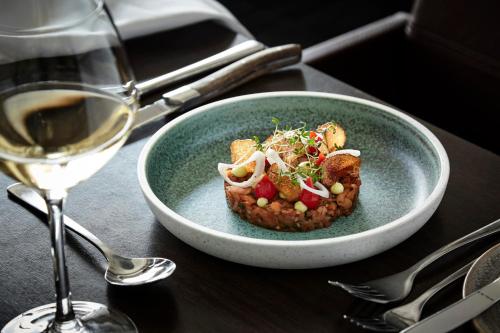 a bowl of food next to a glass of wine at Comwell Middelfart in Middelfart