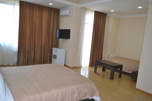 a hotel room with two beds and a tv on the wall at Hotel Skyline Batumi in Batumi