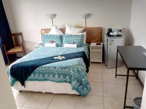 a bedroom with a bed with a blue comforter at Concord Christian Guesthouse in Durban