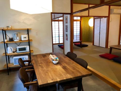 a dining room with a wooden table and chairs at Santiago Guesthouse Naha in Naha