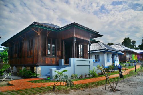 a small wooden house in front of a row of houses at Rock and Wreck Dive Resort in Tanjungbinga