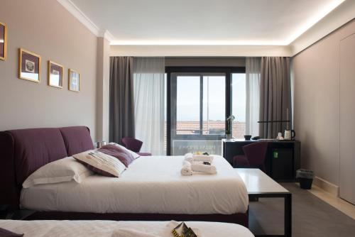 a hotel room with two beds and a window at Principessa Mafalda in Messina