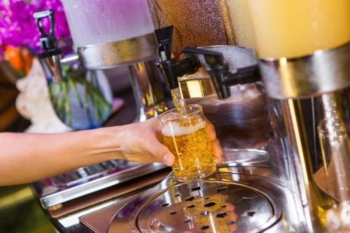 a person is pouring a glass of beer into a coffeemachine at Amaranta Hotel in Bangkok