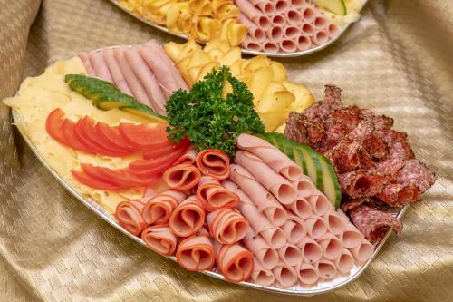 a plate of different types of food on a table at Hotel City Pisek in Písek
