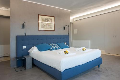 ein blaues Bett mit blauem Kopfteil in einem Schlafzimmer in der Unterkunft Principessa Mafalda in Messina