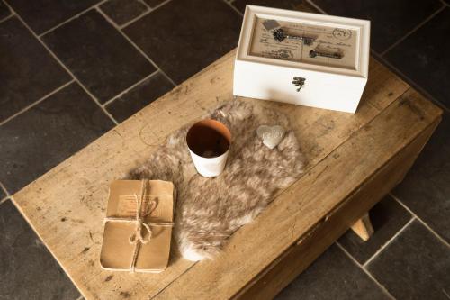 einen Tisch mit einem Buch und einer Tasse Kaffee und einer Schachtel in der Unterkunft Gîte de Corbion in Leignon