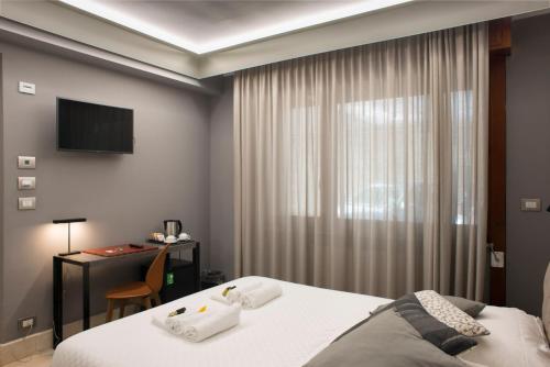a bedroom with a bed and a desk and a television at Principessa Mafalda in Messina