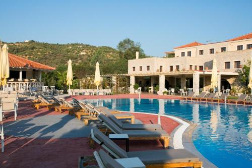 a large swimming pool with lounge chairs and umbrellas at Aktaion Resort in Gythio