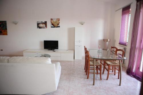 a living room with a table and a couch at Giardino Sul Mare in Vibo Valentia