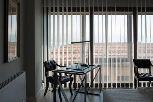 a room with a table and two chairs in front of a window at Principessa Mafalda in Messina