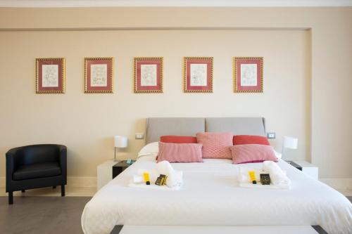 a bedroom with a white bed and a black chair at Principessa Mafalda in Messina