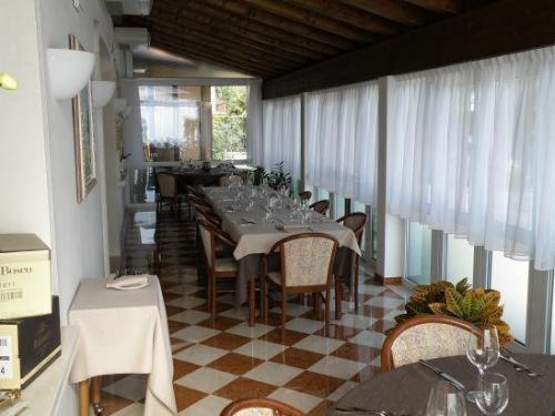 una sala da pranzo con un lungo tavolo e sedie di Hotel Villa Monica a Prata di Pordenone