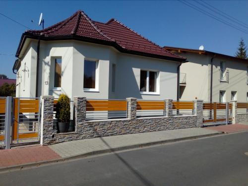 a white house with a fence in front of it at Apartmány Lea in Liptovský Mikuláš